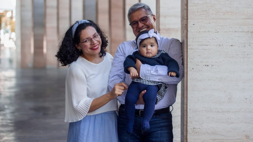 a man and a woman holding a baby in their arms