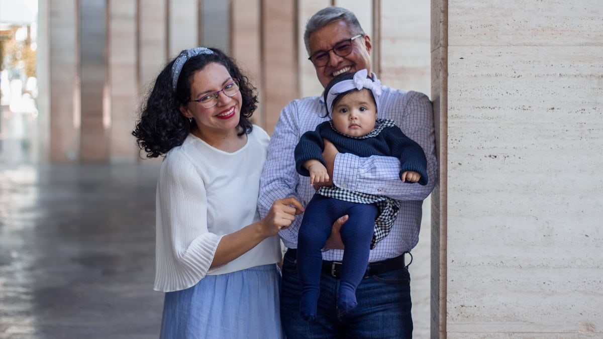 a man and a woman holding a baby in their arms